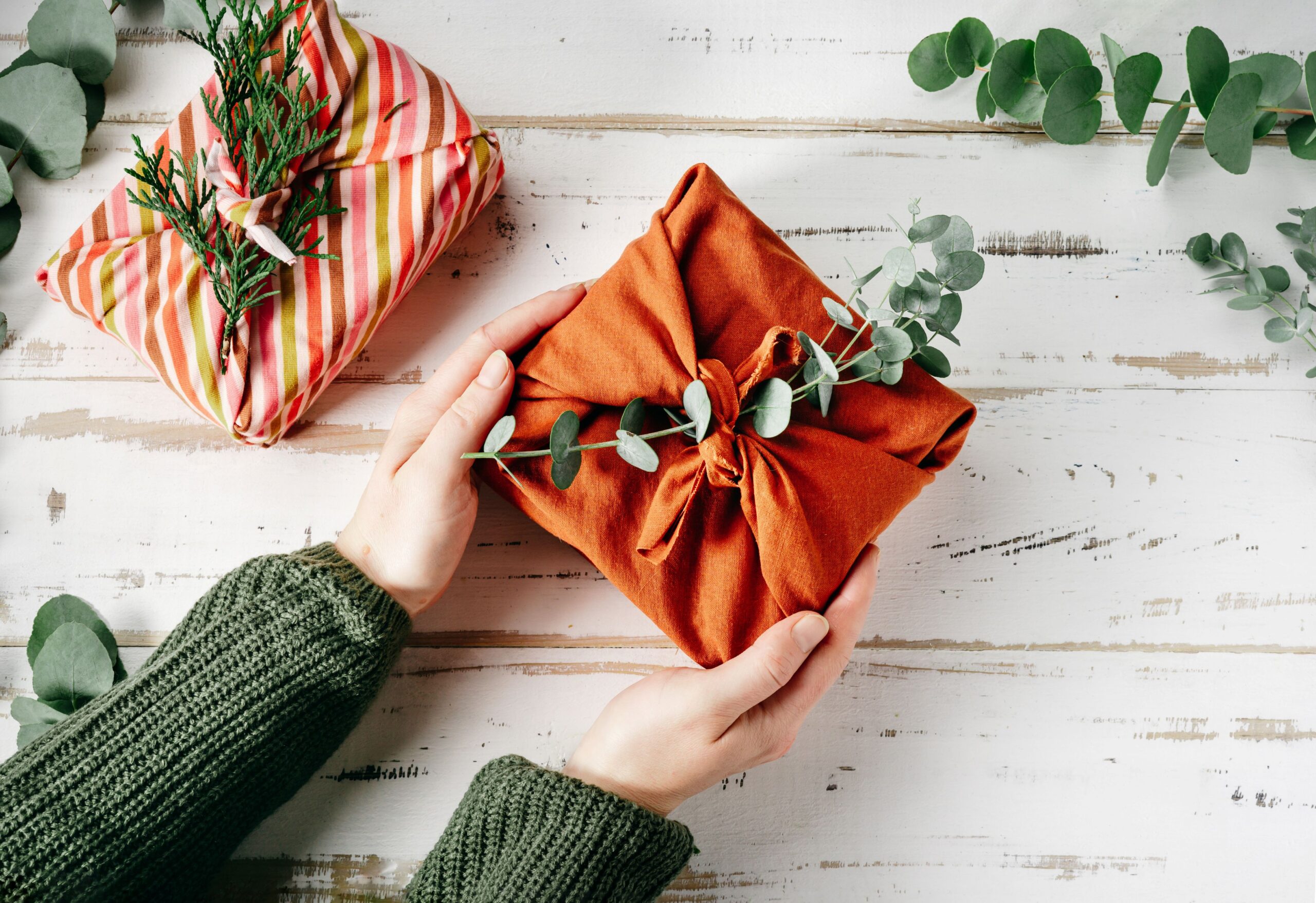 Kreativ verpacktes Geschenk mit Stoff und Eukalyptuszweigen