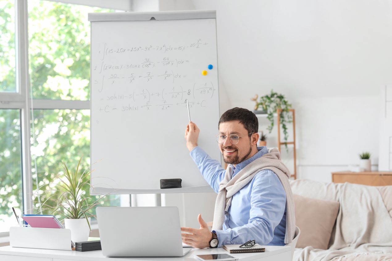 Ein Mathe-Nachhilfelehrer erklärt mathematische Formeln auf einem Whiteboard während einer Mathe Nachhilfe Online Session. Digitale Bildung bequem von zu Hause aus.