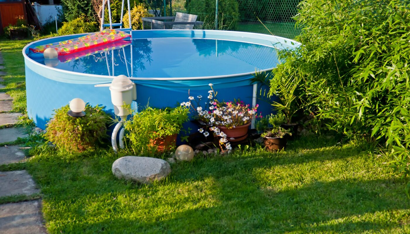 Aufgestellter Rundpool im Garten mit Pflanzen