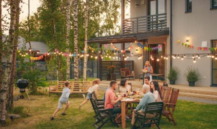 Familie sitzt im Garten bei Sommerfest mit Lichterketten und bunten Wimpeln | Cortenstahl Hochbeet
