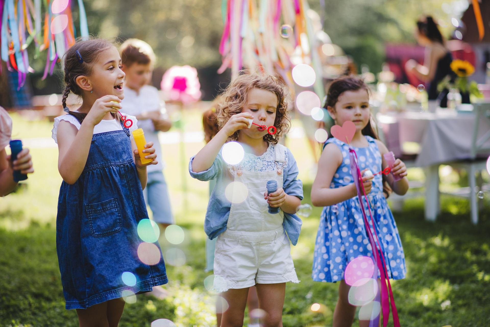 Kinder spielen fröhlich mit Seifenblasen bei Sommerfest im Garten | Cortenstahl Hochbeet