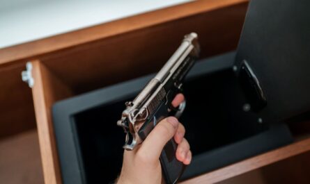 Hand legt eine Schreckschusspistole in einen abschliessbaren Tresor zur sicheren Aufbewahrung