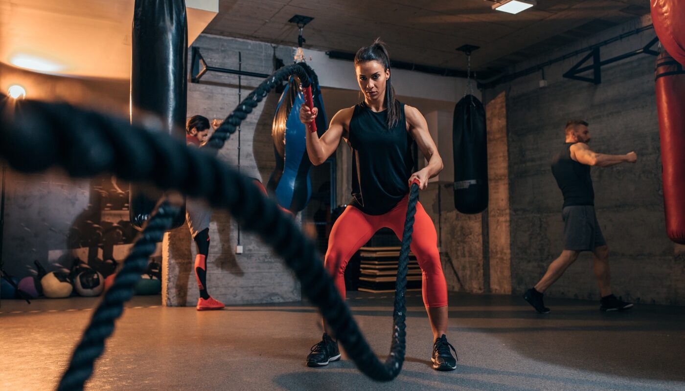 Sportlerin macht intensives Workout mit Seilen | Whey Isolate Protein